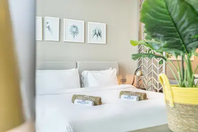 a bedroom with a white bed with three pictures on the wall at Modern Home in Business Bay with Panoramic View in Dubai