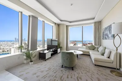 a living room with a couch and a tv and windows at Stunning 1-BR Apartment In Heart Of The Palm in Dubai