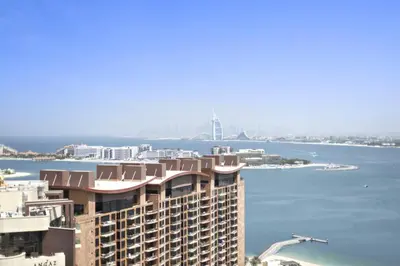 a tall building with a view of a large body of water at Stunning 1-BR Apartment In Heart Of The Palm in Dubai