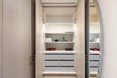 a walk in closet with a mirror and white shelves at Stunning 1-BR Apartment In Heart Of The Palm in Dubai