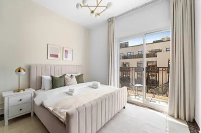 a bedroom with a large bed and a large window at Silkhaus Modern 2BDR in Pantheon Boulevard at JVC in Dubai