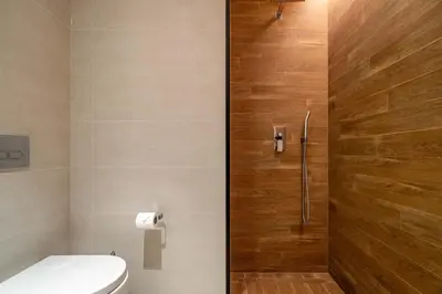 a bathroom with a toilet and a wooden door at GuestReady - Magnificent stay in Bluewaters Island in Dubai