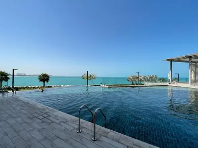 a swimming pool with the ocean in the background at GuestReady - Magnificent stay in Bluewaters Island in Dubai