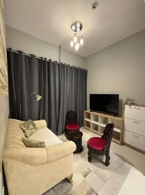 a living room with a couch and a tv at Layali - Chic 1BR with Balcony in Business Bay in Dubai