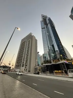 two tall buildings on the side of a city street at Layali - Chic 1BR with Balcony in Business Bay in Dubai