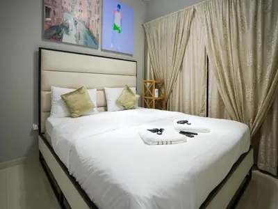 a bedroom with a large white bed with towels on it at Layali - Chic 1BR with Balcony in Business Bay in Dubai