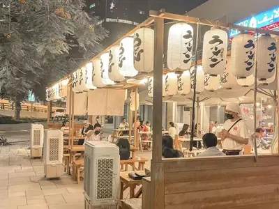 a restaurant with people sitting at tables in a street at Cosmos Living Sleek and Stylish GCV2 in Dubai