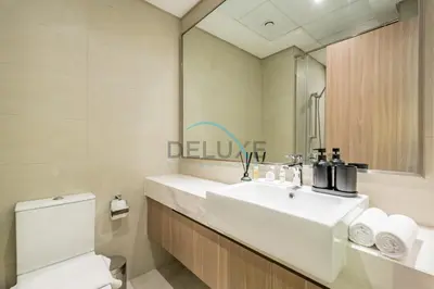 a bathroom with a sink and a toilet and a mirror at Calming Studio Apartment at Azizi Riviera 4, Al Merkadh by Deluxe Holiday Homes in Dubai