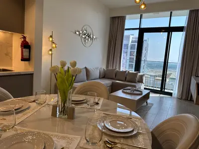 a living room with a table and a couch at ASHRI luxurious apt in Meydan Riviera 44 in Dubai