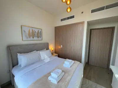a bedroom with a bed with towels on it at ASHRI luxurious apt in Meydan Riviera 44 in Dubai