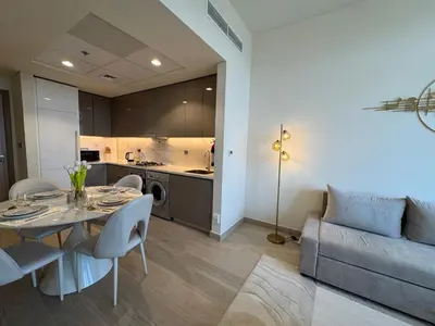 a living room with a table and a couch at ASHRI luxurious apt in Meydan Riviera 44 in Dubai