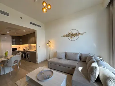 a living room with a couch and a table at ASHRI luxurious apt in Meydan Riviera 44 in Dubai