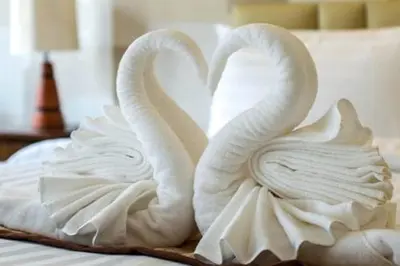two swans made out of towels on a bed at Luxury apartment in Dubai marina 5 min walk to JBR Beach-3BHK Apartment in Dubai
