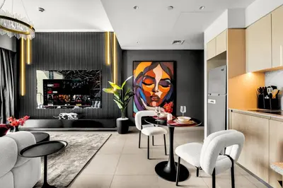 a kitchen with a table with chairs and a painting at Glow Sky Suite Trendy 1BR- Dubai Mall Access by Maxx Value Homes in Dubai
