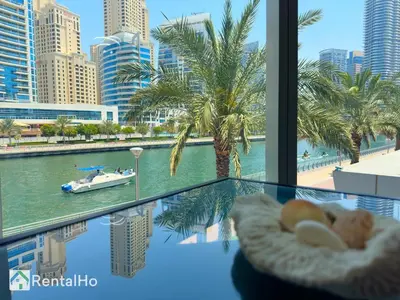 a glass table with a view of a river and a boat at Unforgettable View & Experience Over Dubai Canal in Dubai