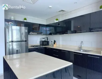 a kitchen with black cabinets and a white counter top at Unforgettable View & Experience Over Dubai Canal in Dubai