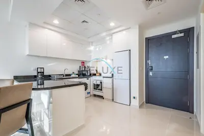 a kitchen with white cabinets and a blue door at Elegant 2BR in Tower 108 Jumeirah Village Circle by Deluxe Holiday Homes in Dubai