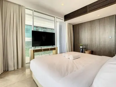 a bedroom with a large white bed with a flat screen tv at FIVE Palm Residence - Elegant Home in Dubai