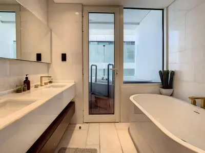 a bathroom with two sinks and a tub and a window at FIVE Palm Residence - Elegant Home in Dubai