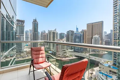 a balcony with two chairs and a view of the city at Gorgeous 2BR APT in Dubai Marina with Canal View in Dubai