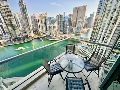 a balcony with a table and chairs and a river at Gorgeous 2BR APT in Dubai Marina with Canal View in Dubai