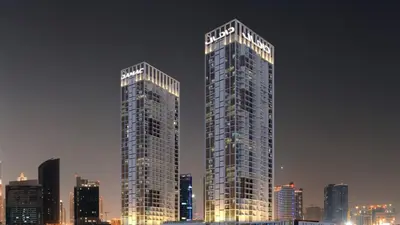 two tall skyscrapers in a city at night at Luxury Smart Studio with Canal View Business Bay - Damac Maison Prive in Dubai