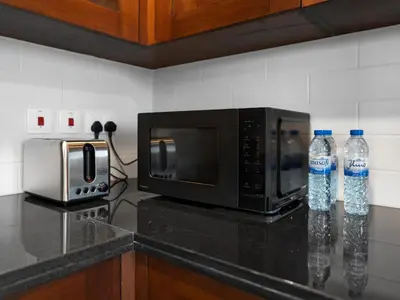 two bottles of water are sitting next to a microwave at New Downtown Setup - Penthouse with Panoramaic Views in Dubai