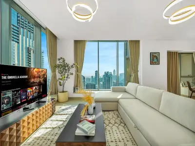 a living room with a large couch and a tv at New Downtown Setup - Penthouse with Panoramaic Views in Dubai