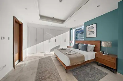 a bedroom with a large bed and a blue wall at Silkhaus New and Stylish 2BR in Dubai Marina in Dubai