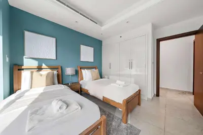 a bedroom with two beds and a blue wall at Silkhaus New and Stylish 2BR in Dubai Marina in Dubai