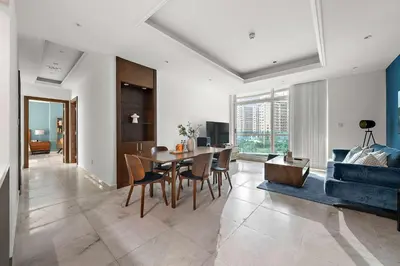a living room with a table and a blue couch at Silkhaus New and Stylish 2BR in Dubai Marina in Dubai