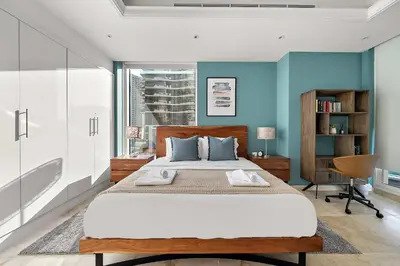 a bedroom with a large bed with blue walls at Silkhaus New and Stylish 2BR in Dubai Marina in Dubai