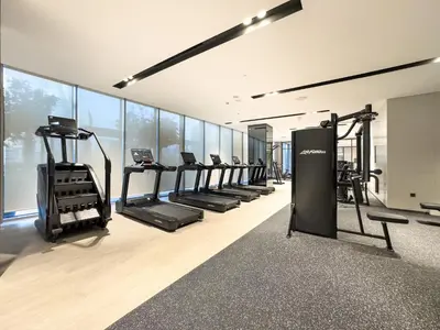 a gym with a row of treadmills and ellipticals at Luxury 1BR 5min to Dubai Mall Burj Khalifa View from pool in Dubai