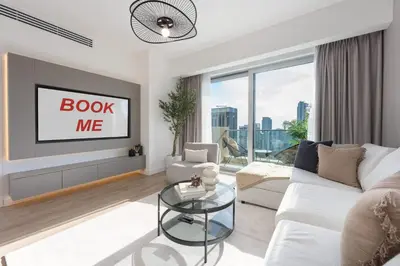 a living room with a white couch and a tv at StayShort - Grand Stay in this 1 Bedroom Flat that Sleeps 4 in Dubai