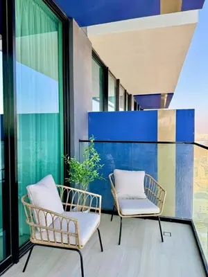 two chairs sitting on a balcony with windows at Modern 1br In Jvc Pool, Balcony & Free Parking in Dubai