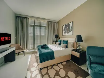 a bedroom with a king sized bed and a blue chair at Modern Studio Escape - Pool, Gym & Relaxation in Dubai