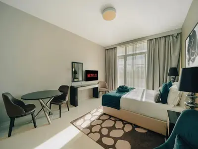 a bedroom with a bed and a table and chairs at Modern Studio Escape - Pool, Gym & Relaxation in Dubai