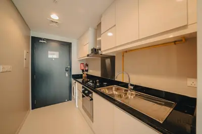 a kitchen with a sink and a black door at Modern Studio Escape - Pool, Gym & Relaxation in Dubai