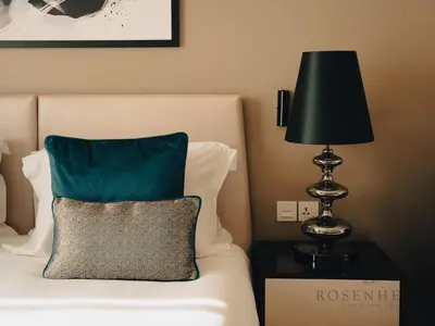a bed with a green pillow and a lamp at Modern Studio Escape - Pool, Gym & Relaxation in Dubai