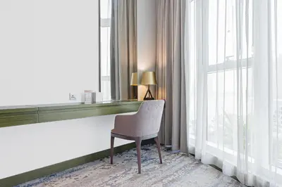 a chair sitting in a room next to a window at Escape24 Cozy Studio with Pool & Canal View near Burj Khalifa in Dubai