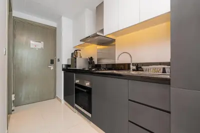 a kitchen with a sink and a counter top at Escape24 Cozy Studio with Pool & Canal View near Burj Khalifa in Dubai