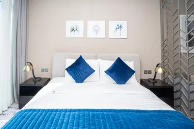 a bedroom with a large white bed with blue pillows at Escape24 Cozy Studio with Pool & Canal View near Burj Khalifa in Dubai