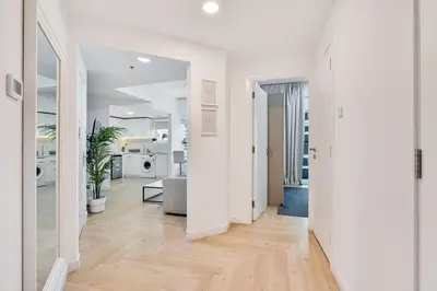 a living room with white walls and wooden floors at Urban Gem 2BR with Stunning Views in Dubai