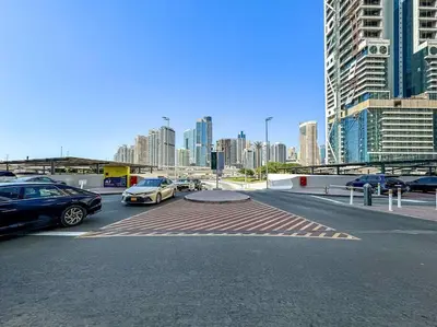 a parking lot with cars parked in front of a city at Urban Gem 2BR with Stunning Views in Dubai