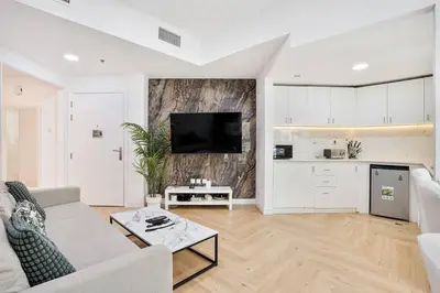 a white living room with a couch and a table at Urban Gem 2BR with Stunning Views in Dubai