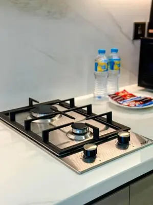a stove top on a counter with two bottles of water at Naseem Elegant Studio Escape in Al Merkadh in Dubai