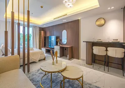 a room with a bed and a living room with a table at Luxurious Studio with Stunning Burj Khalifa, Pool & Lake Views Steps from Dubai Mall in Dubai