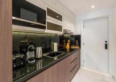 a kitchen with a black counter top with a sink at Luxurious Studio with Stunning Burj Khalifa, Pool & Lake Views Steps from Dubai Mall in Dubai