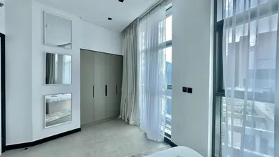 a bedroom with white walls and large windows at 2BR with Extra-Large Balcony Canal & Burj Views by Vibel in Dubai