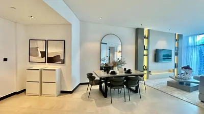 a dining room with a table and chairs and a mirror at 2BR with Extra-Large Balcony Canal & Burj Views by Vibel in Dubai